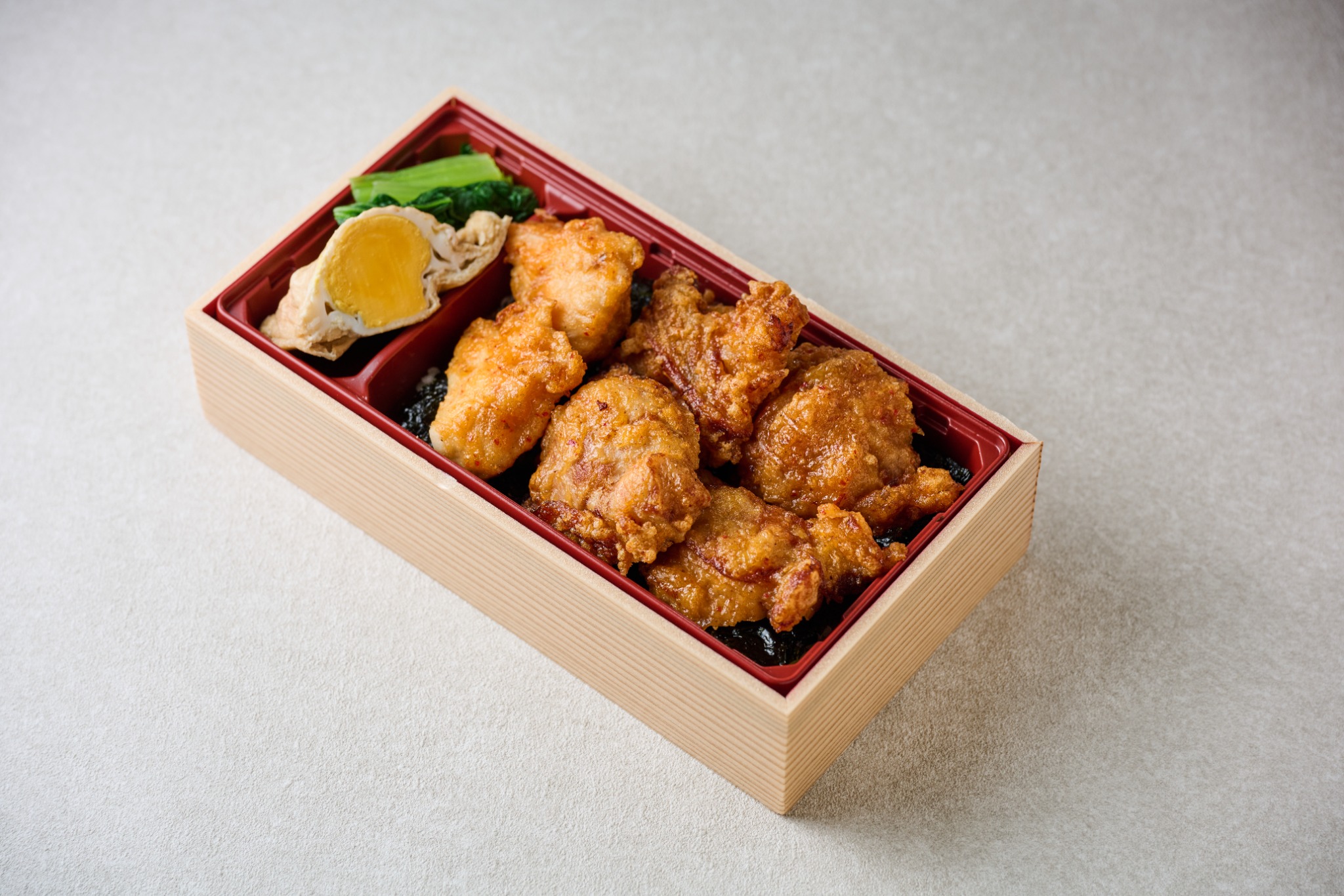 醤油ダレが染みたご飯にから揚げをのせ、卵の副菜を添えたから揚げの海苔弁